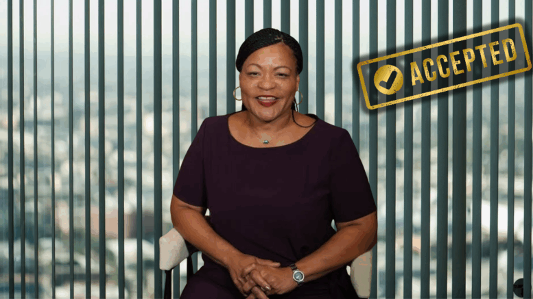 New Orleans Mayor LaToya Cantrell smiles in front of vertical blinds with an “ACCEPTED” stamp overlaid, following her admission into Louisiana’s political leadership program.
