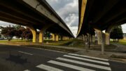 A view under two elevated highway overpasses in Louisiana showing cracked concrete supports and a large pothole in the foreground, reflecting conditions noted in the Louisiana infrastructure report card.