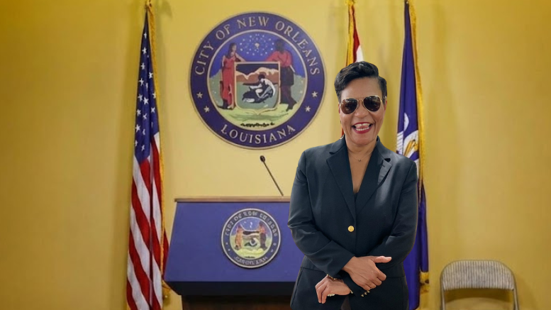 Mayor LaToya Cantrell stands at a City of New Orleans podium during an announcement related to her future in office, with city seal and flags behind her.