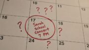 Calendar date circled in red marker with “Sarah school concert 7 PM” handwritten beside several skeptical question marks