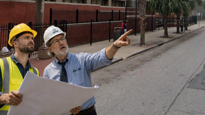 Satirical image of two engineers inspecting Tulane's Charity Hospital redevelopment while diagnosing the renderings with "early-stage optimism" in New Orleans.