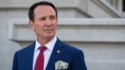 Louisiana Gov. Jeff Landry with cash visible in his suit pocket during a story about NDAs and government transparency.