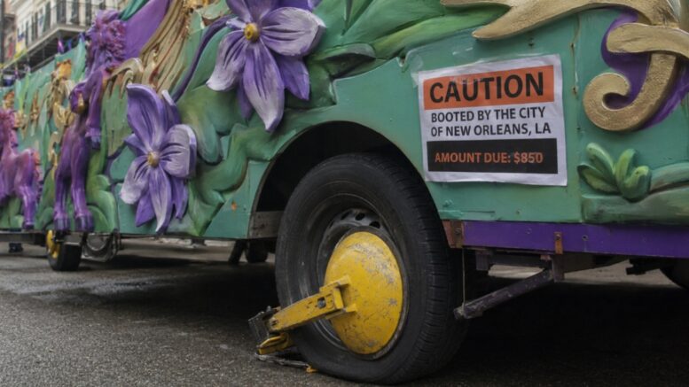 Mardi Gras float immobilized with a City of New Orleans wheel boot and an $850 fee notice.