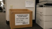 Box of standardized player injury notice forms for right hamstring injuries and two-week recovery timelines beside an office copier.