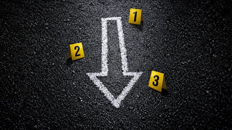 White chalk downward arrow surrounded by evidence markers representing falling crime in New Orleans.